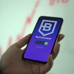 Mão segurando um smartphone com a tela de uma carteira digital de criptomoedas e tecnologia blockchain.