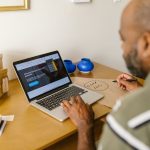 Empreendedor trabalha em uma mesa usando um laptop em um ambiente de escritório.